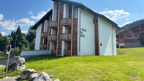 A building with balconies and a sign reading "L'Erve du Bois". - Renovated Apartment in La Turche, Les Gets - 1BR, Sleeps 4, Balcony, Parking, Ski Storage (Les Gets)
