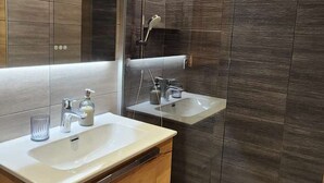A modern bathroom with two sinks, a mirror, and a shower. - Renovated Apartment in La Turche, Les Gets - 1BR, Sleeps 4, Balcony, Parking, Ski Storage (Les Gets)