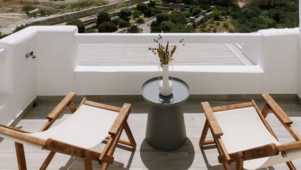 A terrace with a view of the sea, a table with a vase, and two wooden chairs. - Hidden Gem, 2Br Family Villa, with Sea View | Naxos Mikri Vigla Beach (Naxos)