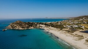 An aerial view of a coastal area with a rocky island, clear blue waters, and a beach with white buildings. - Hidden Gem, 2Br Family Villa, with Sea View | Naxos Mikri Vigla Beach (Naxos)