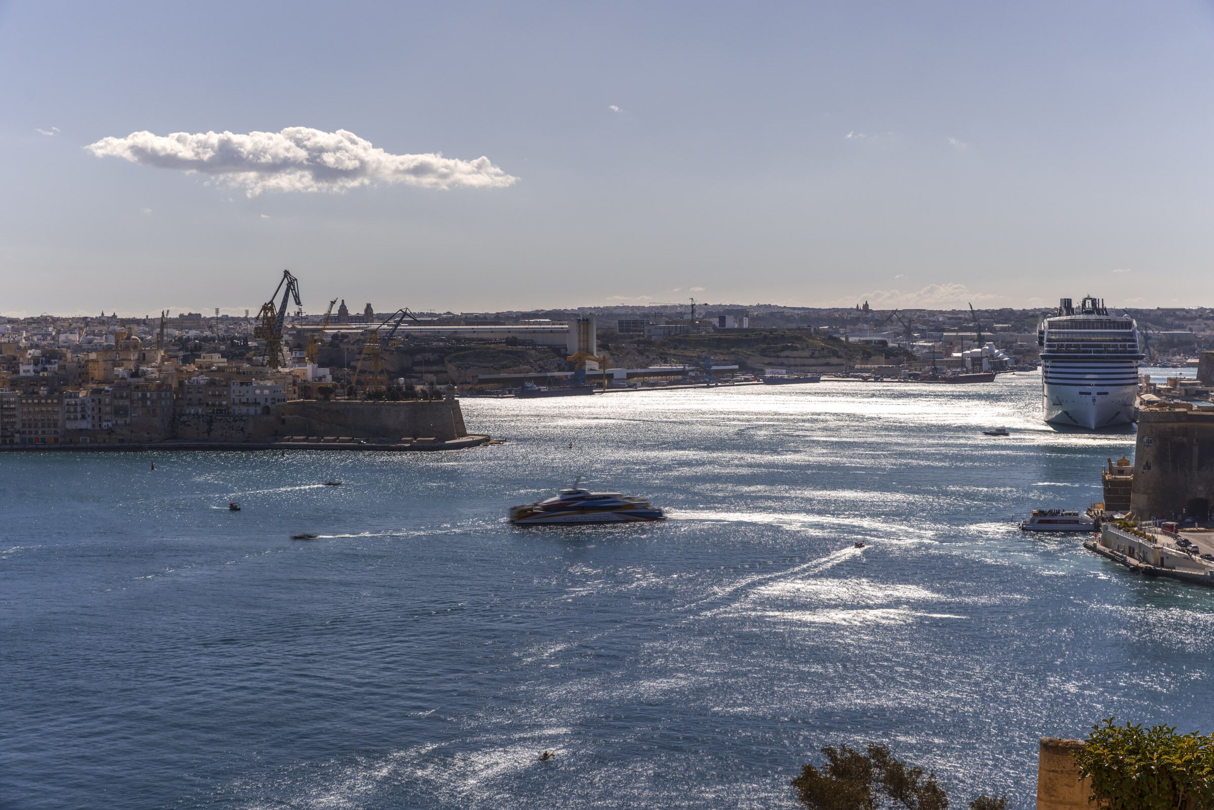 A harbor with ships, a bridge, and a cityscape in the background.