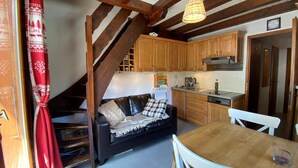 Eine gemütliche Küche mit Holzschränken, einem Esstisch und einem Sofa im Wohnbereich.