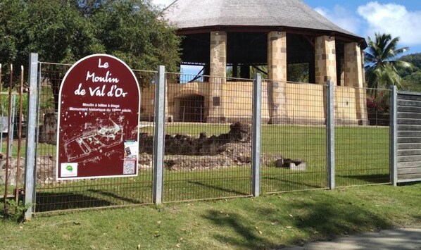 A fenced area with a sign for 'Le Moulin de Val d'Or' and a historical monument.