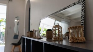A modern interior with a black console table, wicker baskets, and a mirror with a zebra-striped frame.