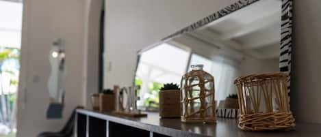 A modern interior with a black console table, wicker baskets, and a mirror with a zebra-striped frame.