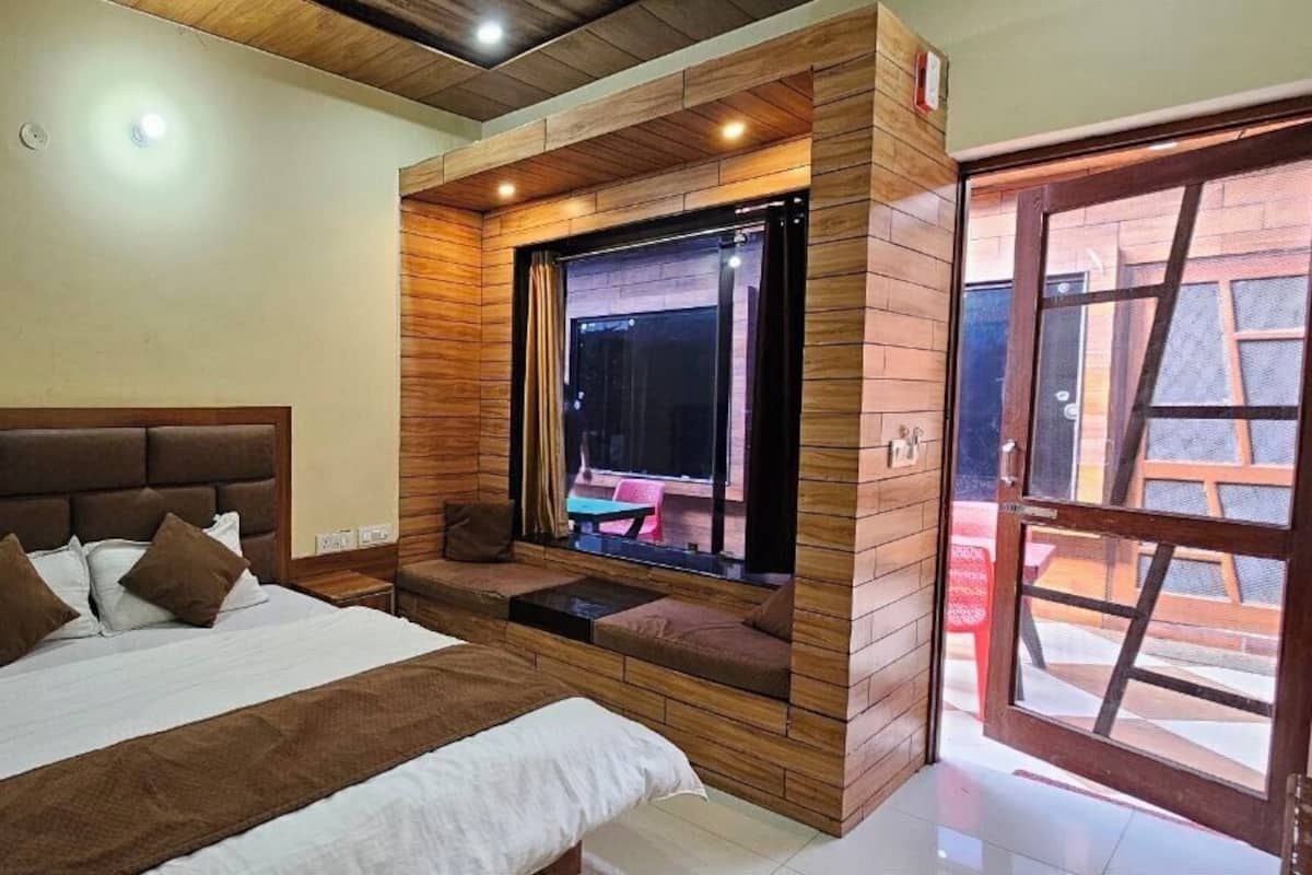 Ein Schlafzimmer mit einem großen Bett, einem Fenster mit Blick nach draußen und einer Wand mit Holzverkleidung.
