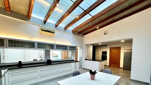A modern kitchen with a central island, white cabinetry, and a skylight above. - Beloura (Sintra)