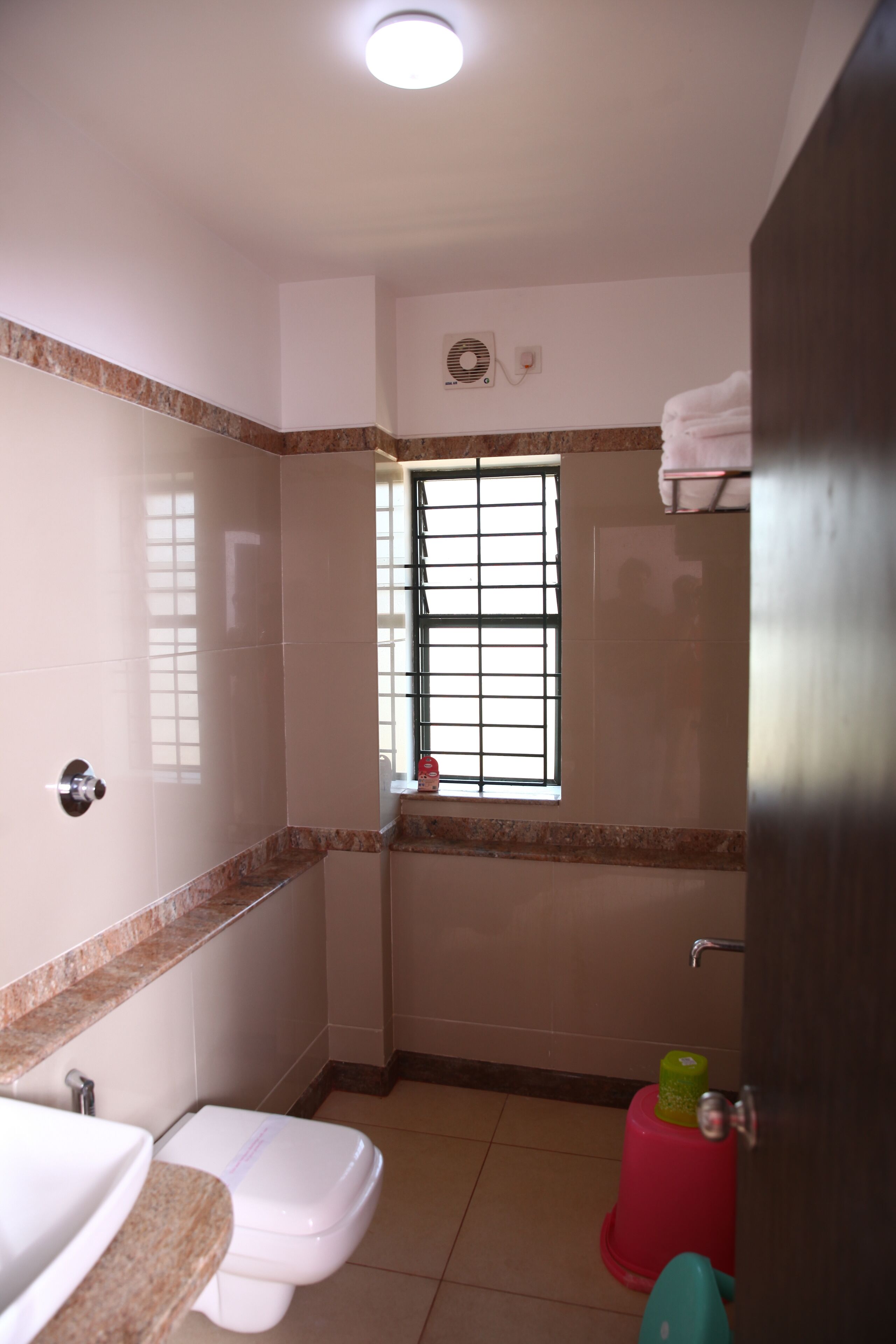 A small bathroom with a toilet, sink, and a window.