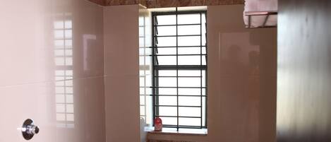 A small bathroom with a toilet, sink, and a window.