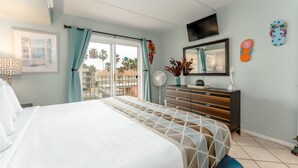 Un dormitorio con cama, cómoda, espejo y televisor.