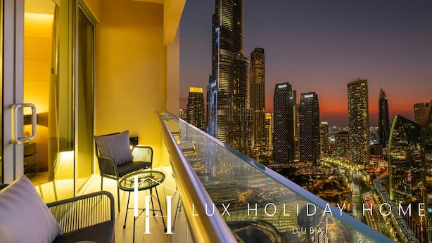 A balcony with a city view, including the Burj Khalifa, and a seating area with a table and chairs.