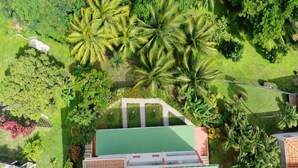 An aerial view of a property with multiple green-roofed buildings, surrounded by lush greenery and palm trees. - Verbena at the Refuge de Madiana in Schoelcher 1036 eg-supply-onboarding-api eg-supply-onboarding-api (Schoelcher)