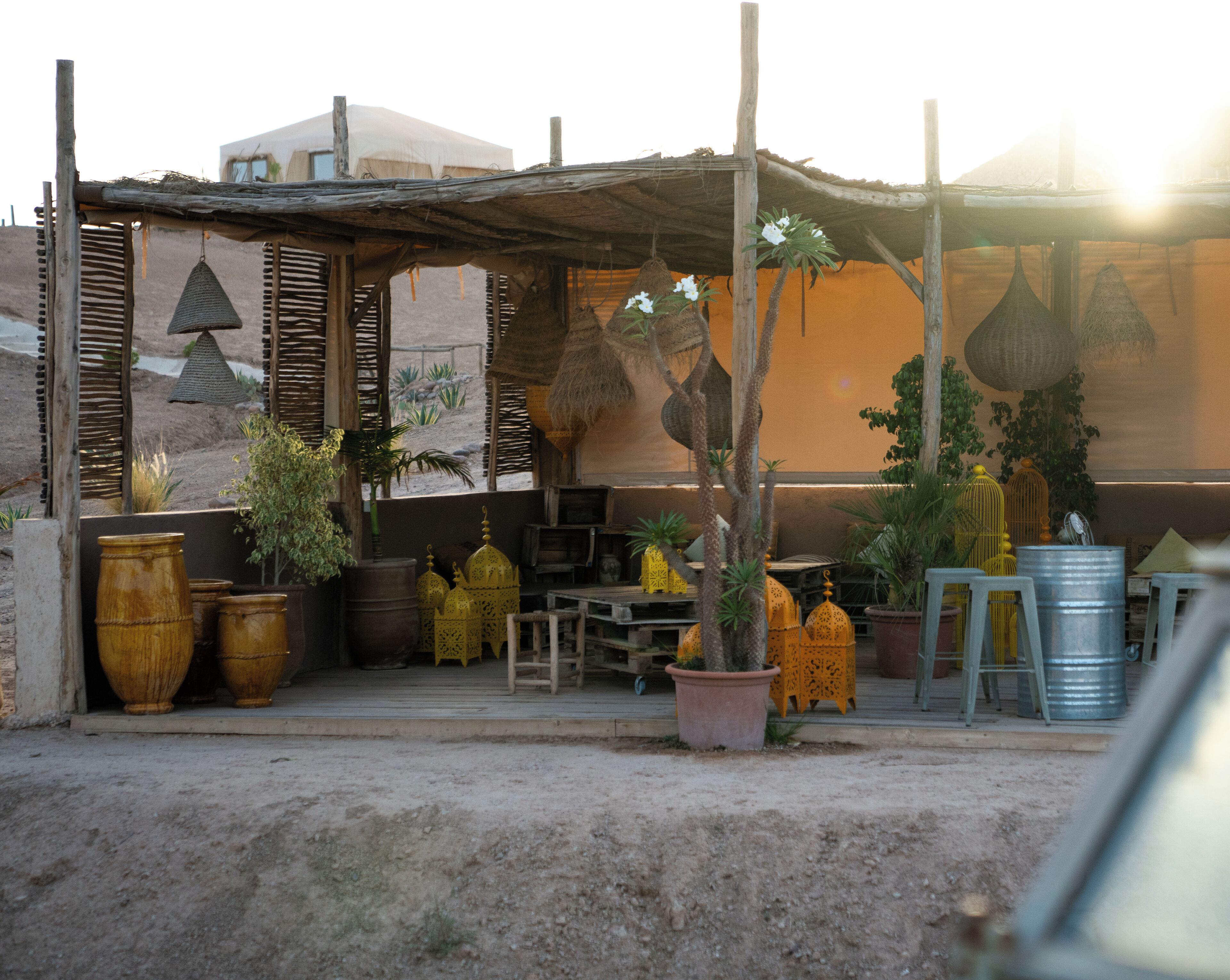 Un espacio de estar al aire libre de estilo rústico con muebles de madera, plantas en macetas y decoración tradicional.