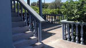 A staircase with balustrades leading to a covered area, surrounded by greenery and a clear sky. - Captivating and Spacious 2-bed House in Vranovici (Ljesevici)