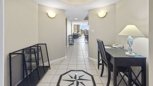A hotel hallway with a tiled floor, a desk with a lamp, and a phone on the desk. - Yacht Club Villas #3-403 Spectacular Waterway View Condo! (North Myrtle Beach)