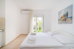 Una camera d'albergo con un letto, un quadro e una vista dal varco della porta.