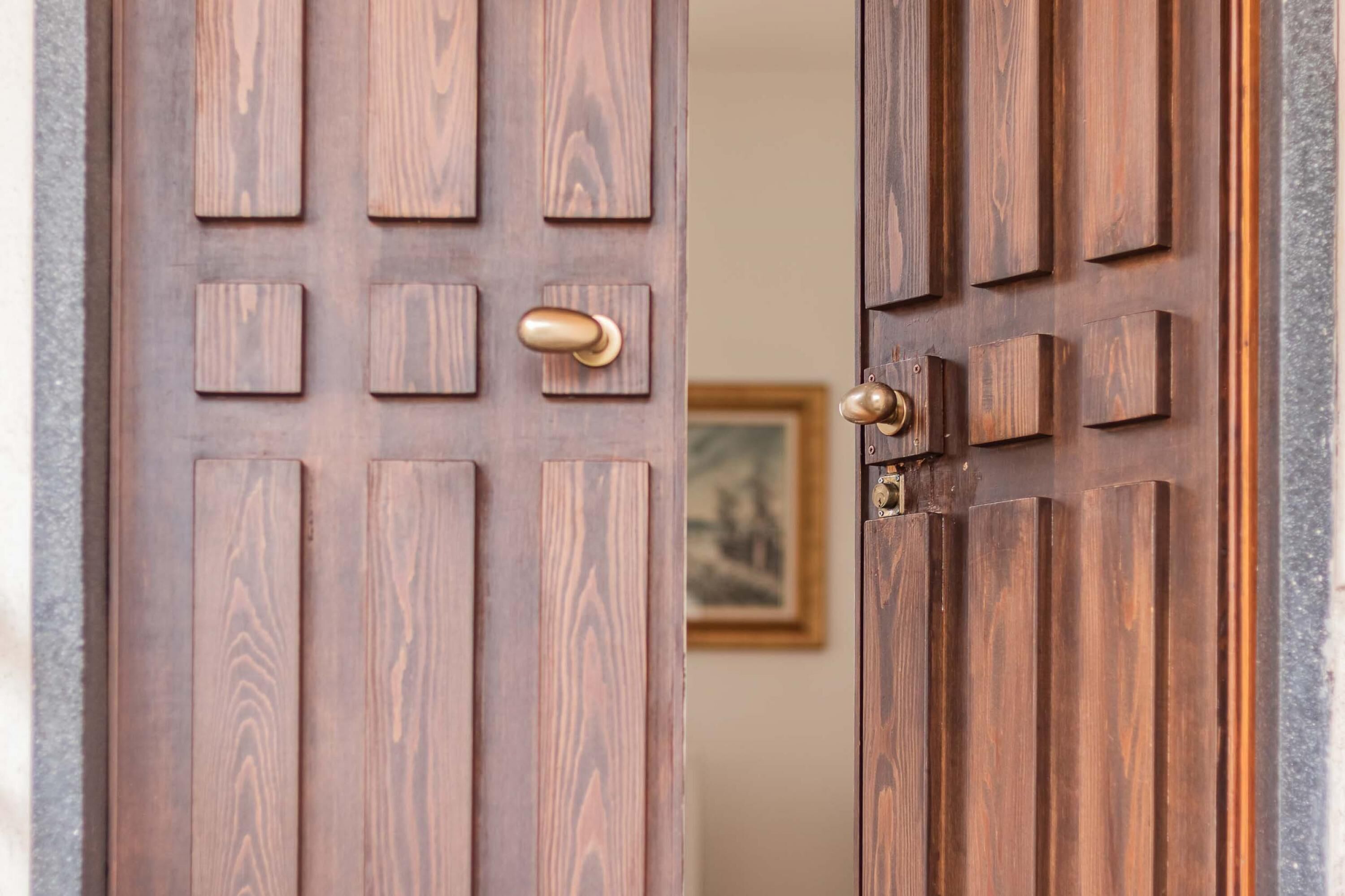 A wooden door with a brass handle and a keyhole.