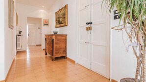 Ein Flur mit einem Holzschrank, einer Zimmerpflanze und einer Tür mit Schlüsselloch.