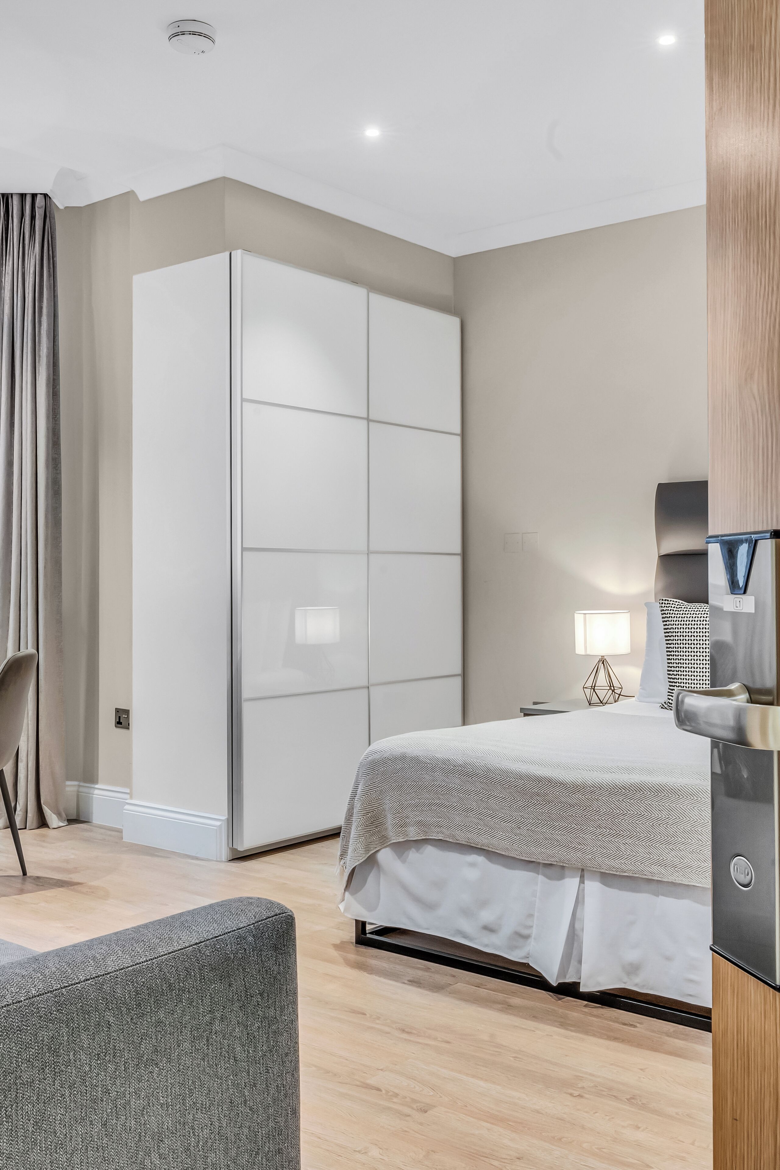 Un dormitorio moderno con una cama, un armario, un escritorio y una silla.