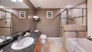 Une salle de bain moderne avec un double lavabo, une douche à parois de verre et une baignoire.