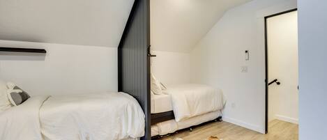 Quarto com duas camas, um tapete de couro bovino e uma porta.