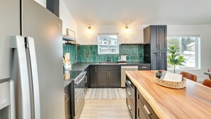 A modern kitchen with dark cabinets, a wooden countertop, and a built-in oven. - Family-friendly Donnelly Home w/ Private Hot Tub! (Donnelly)