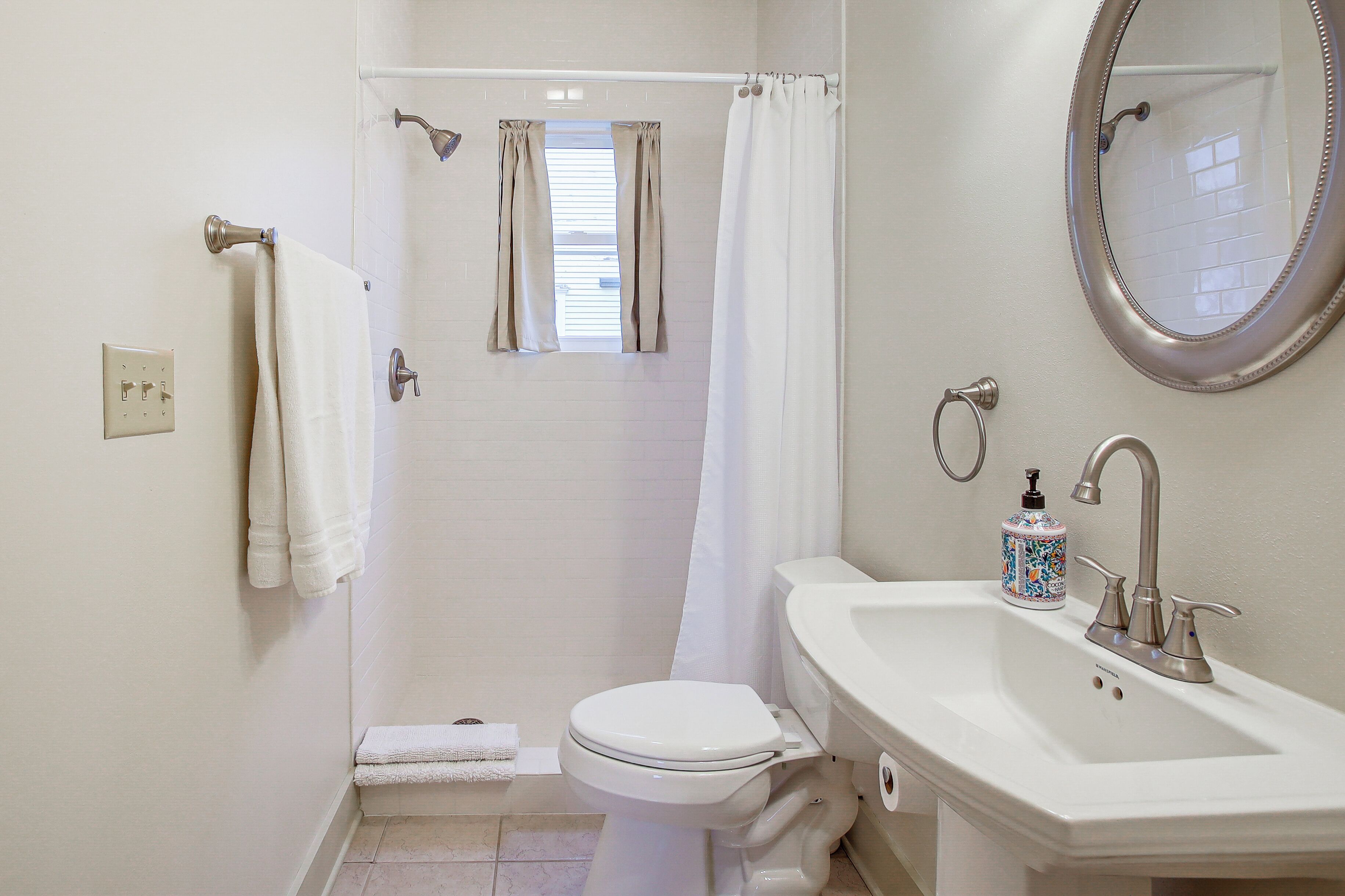 A bathroom with a toilet, sink, and shower.