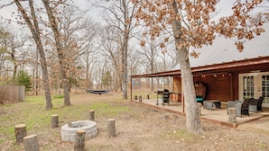 A rustic cabin with a fire pit, outdoor seating, and a hammock. - Near Lake Fork: Home w/ Fire Pit in Yantis! (Yantis)