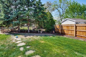 A fenced backyard with a wooden shed, a tree, and a stone pathway. - 4 Mi to Olde Town Arvada! Dog-friendly Home, Yard (Arvada)