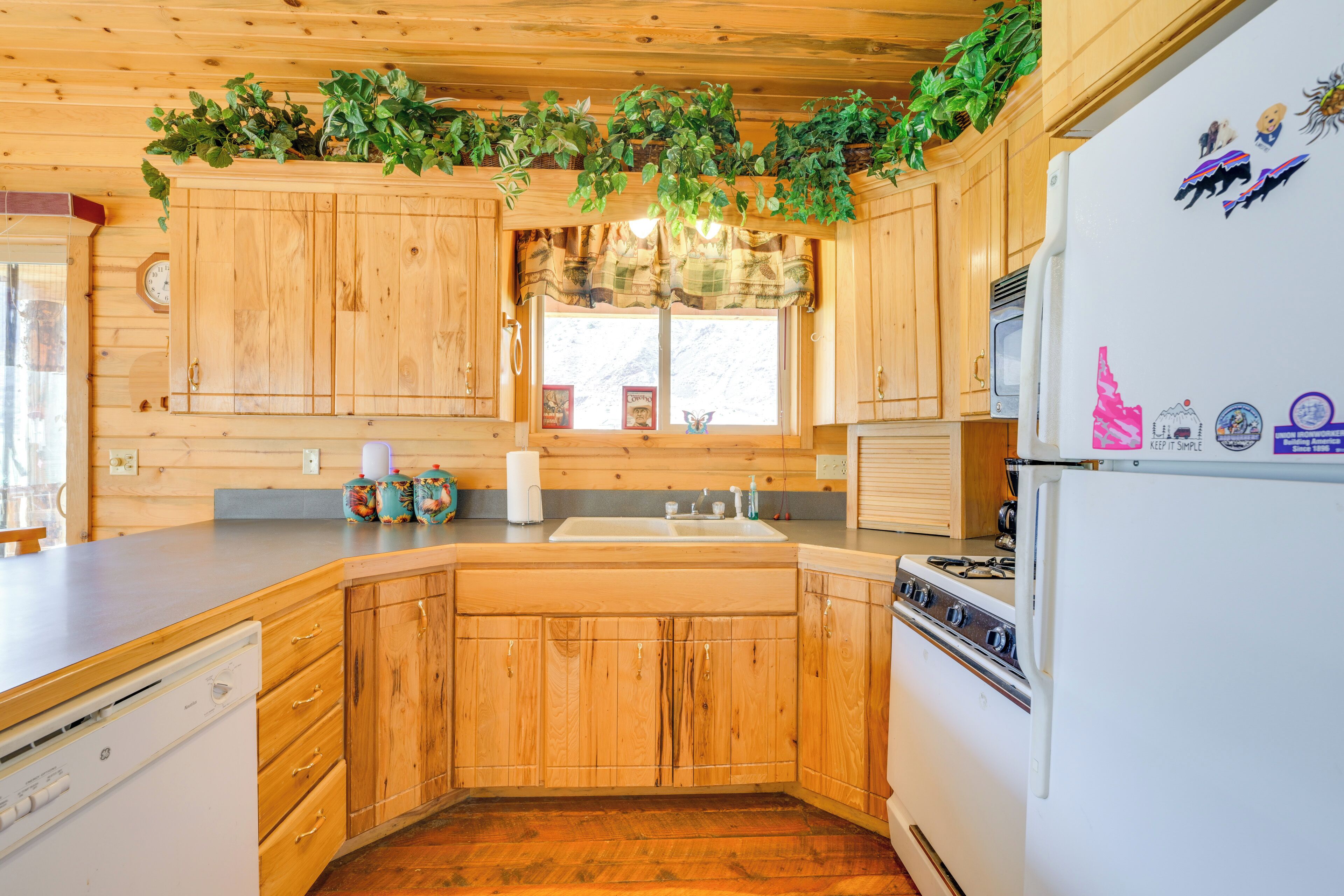 A kitchen with wooden cabinets, a sink, a stove, and a refrigerator.