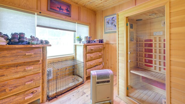 A wooden cabin interior with a sauna, a pet cage, and a window with blinds. - Salmon Vacation Rental w/ Mountain Views! (Salmon)