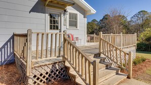 A house with a wooden deck, a front door, and a 'HOME' sign. - Quiet Grove Hill Cottage w/ Wraparound Deck! (Grove Hill)