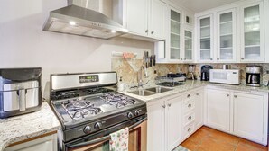 A modern kitchen with white cabinets, a stainless steel stove, and a microwave. - Dog-friendly Albuquerque Home: 1 Mi to U of NM! (Albuquerque)