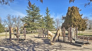 A playground with various equipment including swings, slides, and climbing structures. - Dog-friendly Albuquerque Home: 1 Mi to U of NM! (Albuquerque)
