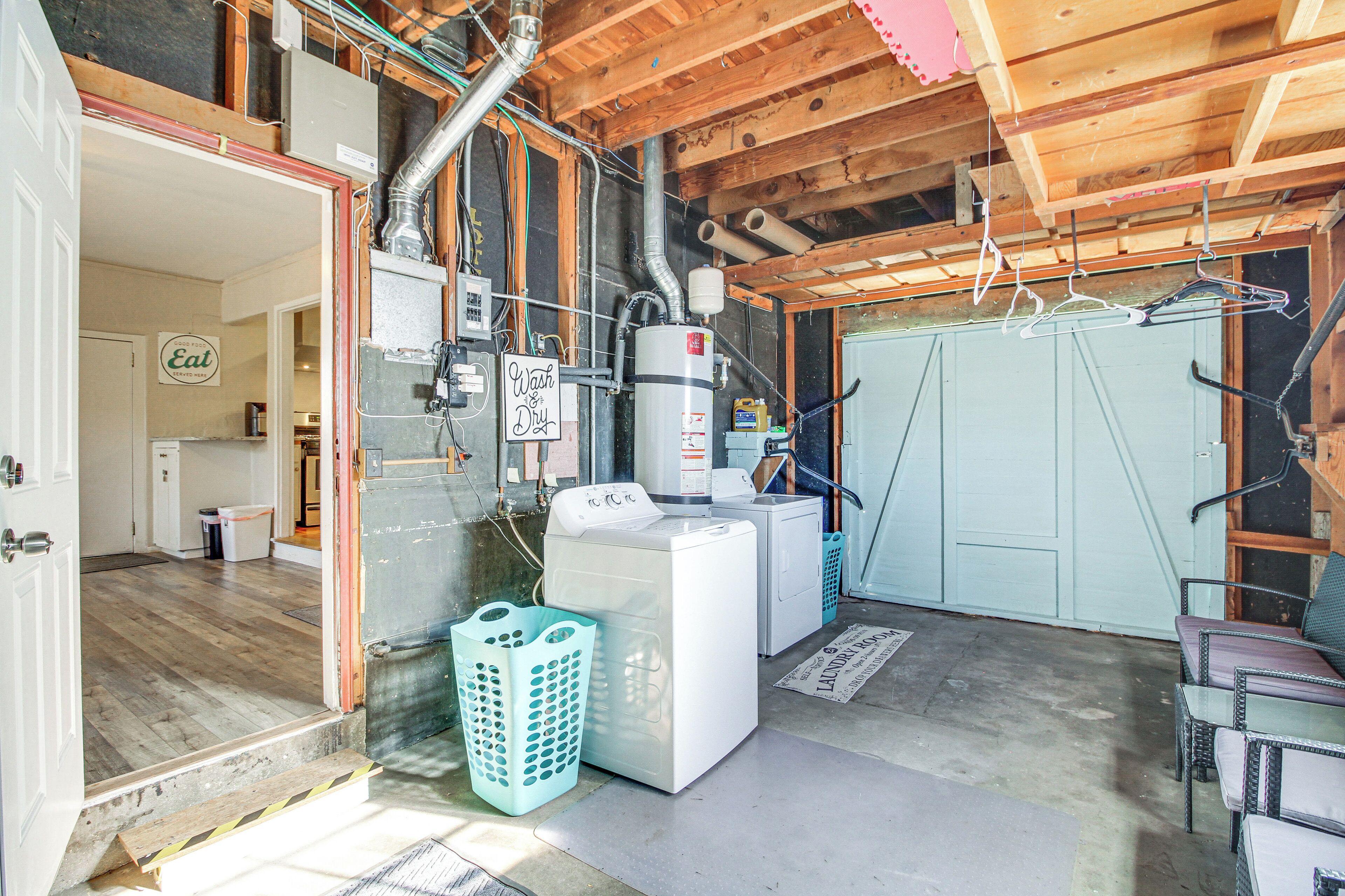 A laundry room with a washing machine, dryer, and clothes drying rack.