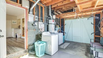 A laundry room with a washing machine, dryer, and clothes drying rack.