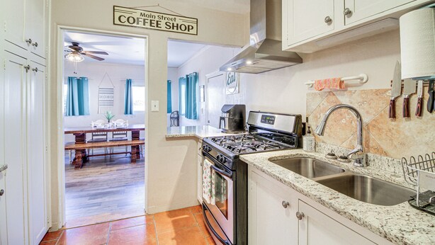 A kitchen with a stove, sink, and cabinets. There is a sign above the door that reads "Main Street Coffee Shop." - Dog-friendly Albuquerque Home: 1 Mi to U of NM! (Albuquerque)
