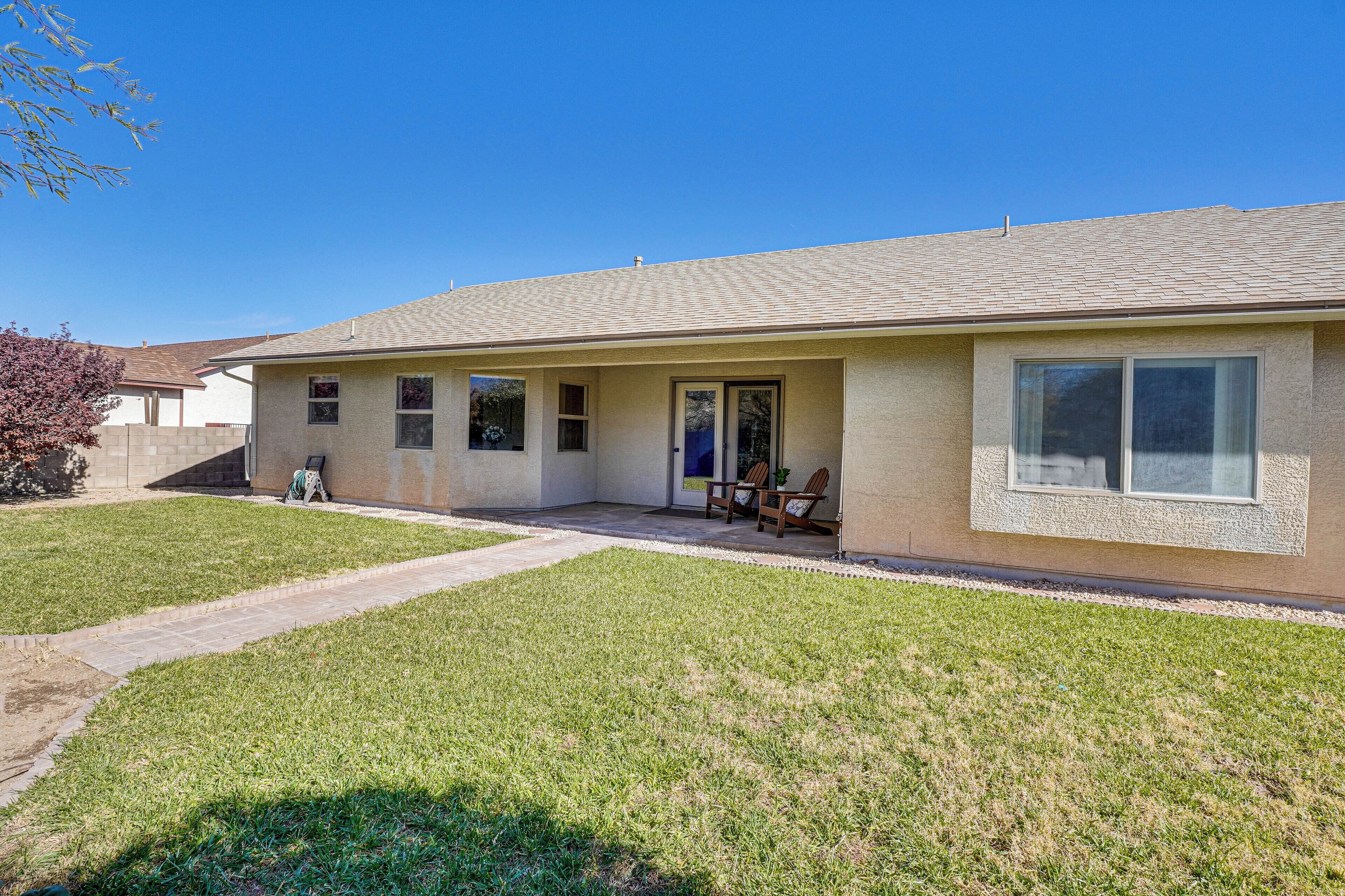 A single-story house with a front porch, a small patio, and a well-maintained lawn.