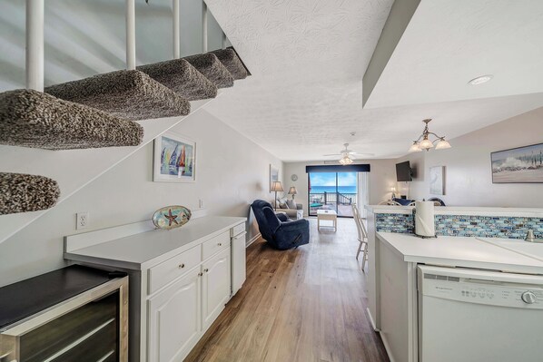 A modern kitchen with white cabinetry, a wooden floor, and a view to the outside. - Surf Dr Townhome Where the Beach is your Backyard! FREE Golf & Perks! (Panama City Beach)
