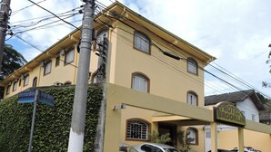 Un edificio con un cartel que dice "Hotel Brooklin" y coches aparcados en la parte delantera.