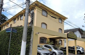 A building with a sign reading "Hotel Brooklin" and parked cars in front. - Hotel Brooklin (São Paulo)
