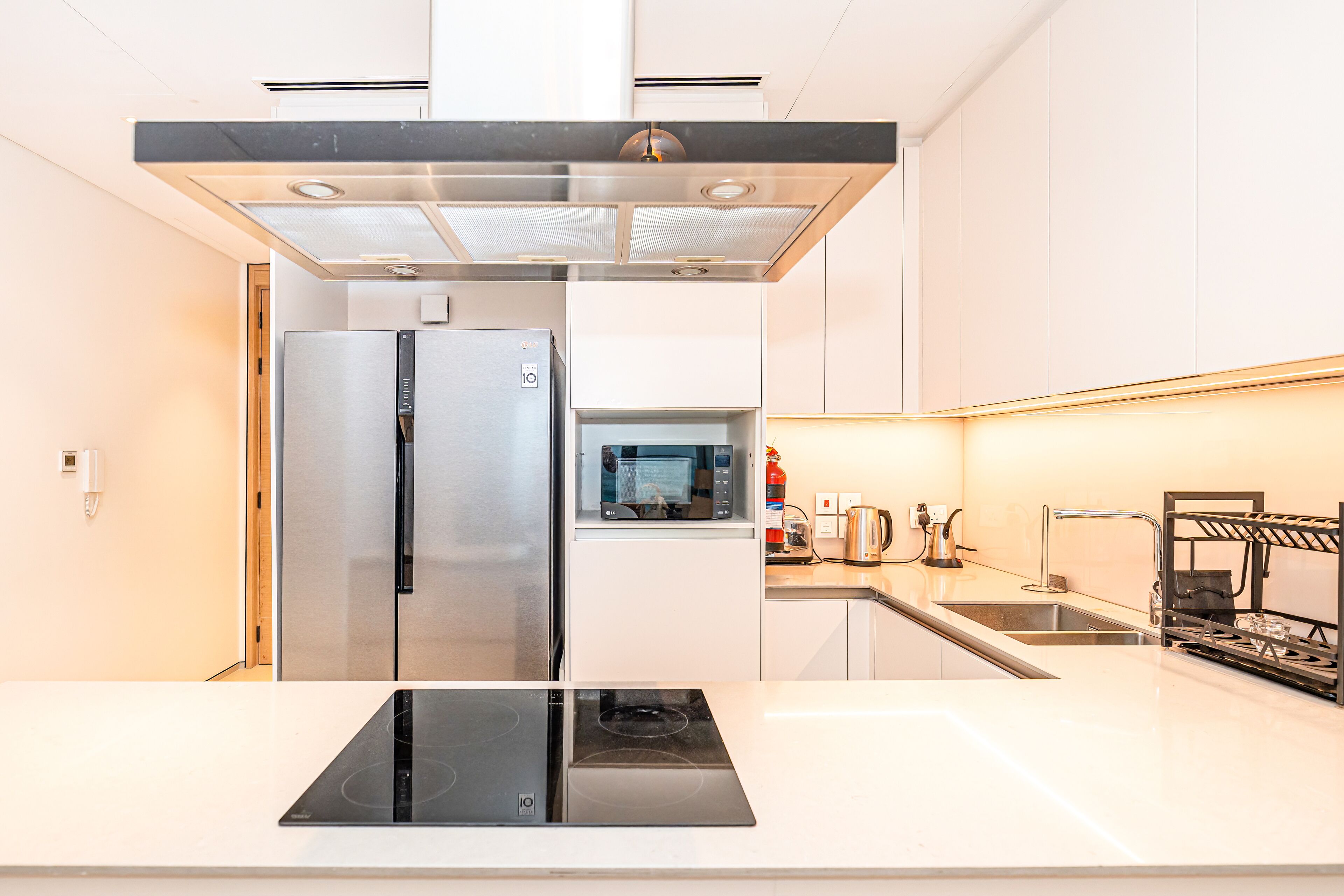 Een moderne keuken met een roestvrijstalen koelkast, een inbouwmagnetron en een gasfornuis.