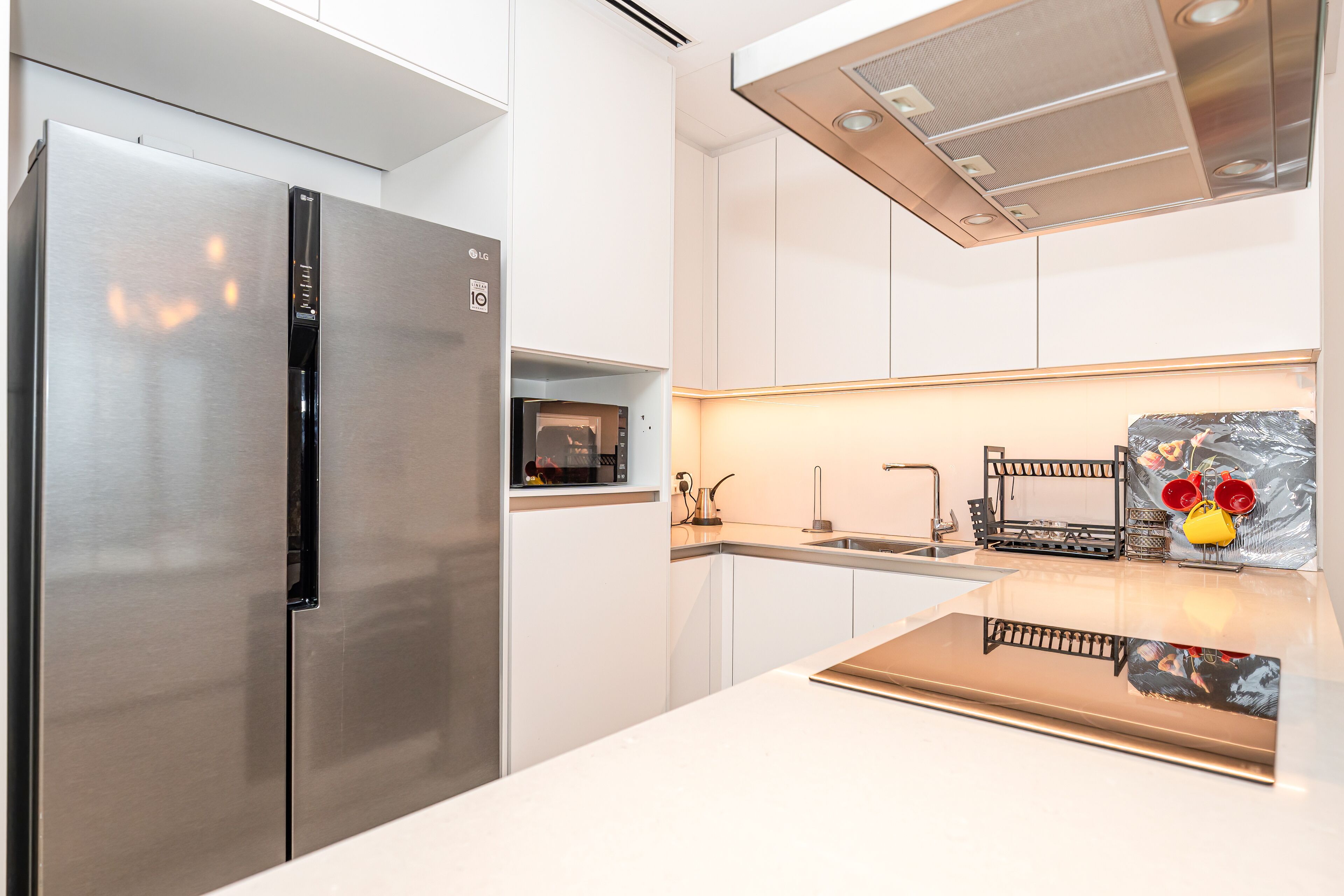 A modern kitchen with a stainless steel refrigerator, a microwave, and a sink.