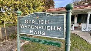 A historical sign for the Gerlich-Wagenfuehr Haus, dating back to 1858, indicating it is a preserved property managed by the New Braunfels Conservation Society.