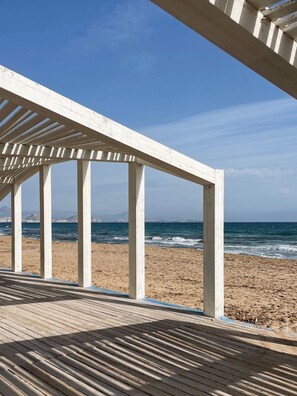 A wooden pier with a clear view of the ocean and a distant city skyline. - Modern coastal apartment Muchavista (El Campello)