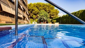 A swimming pool with clear blue water, surrounded by a tiled deck and a metal pool ladder. - Longbeach Smart Muchavista (El Campello)