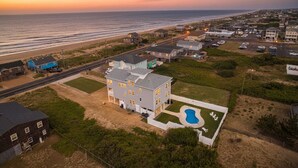 A large house with a swimming pool, located near a beach and a road. - The Sandbar - Kitty Hawk MP 2.5, Semi Oceanfront, Ocean View, Elevator, Pool, Hot Tub (Kitty Hawk)