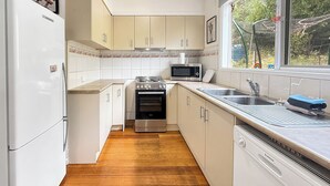 A kitchen with white cabinets, a stainless steel stove, a microwave, and a dishwasher. - Christensen - Pet Friendly home at the base of Mt Buller (Sawmill Settlement)