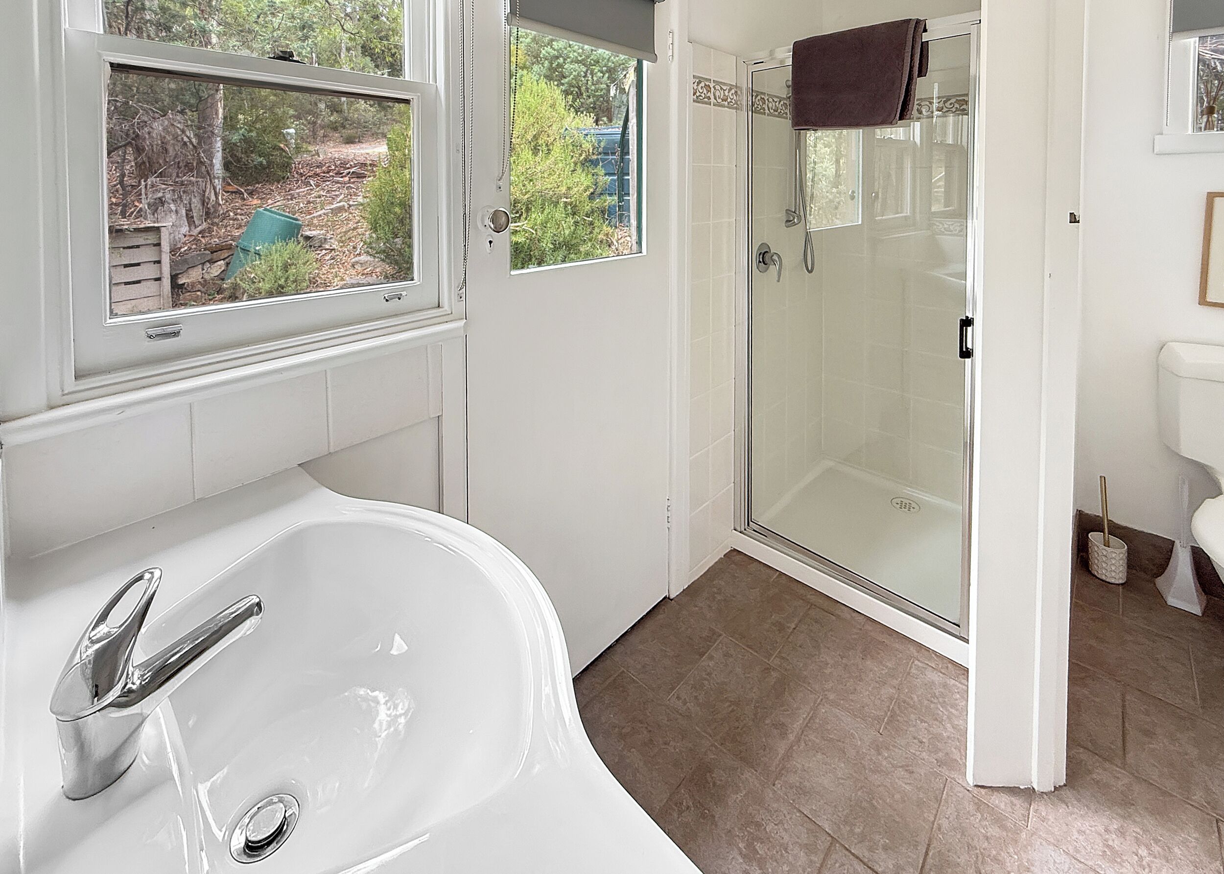 A bathroom with a bathtub, a glass-enclosed shower, and a toilet.