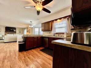 A kitchen with wooden cabinets, a built-in oven, and a ceiling fan.